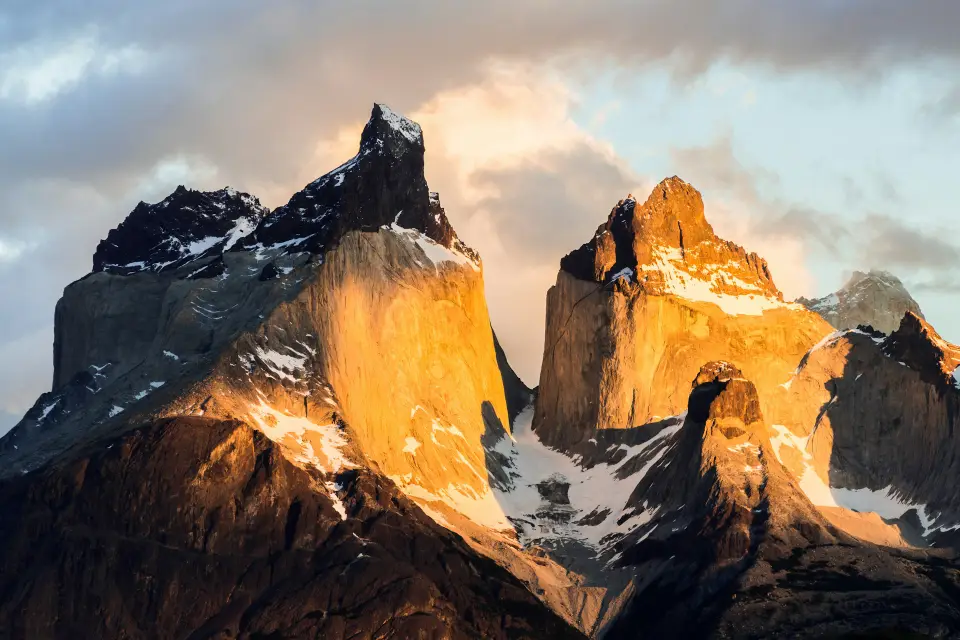 Windswept Patagonian steppe stretching toward jagged peaks at first light