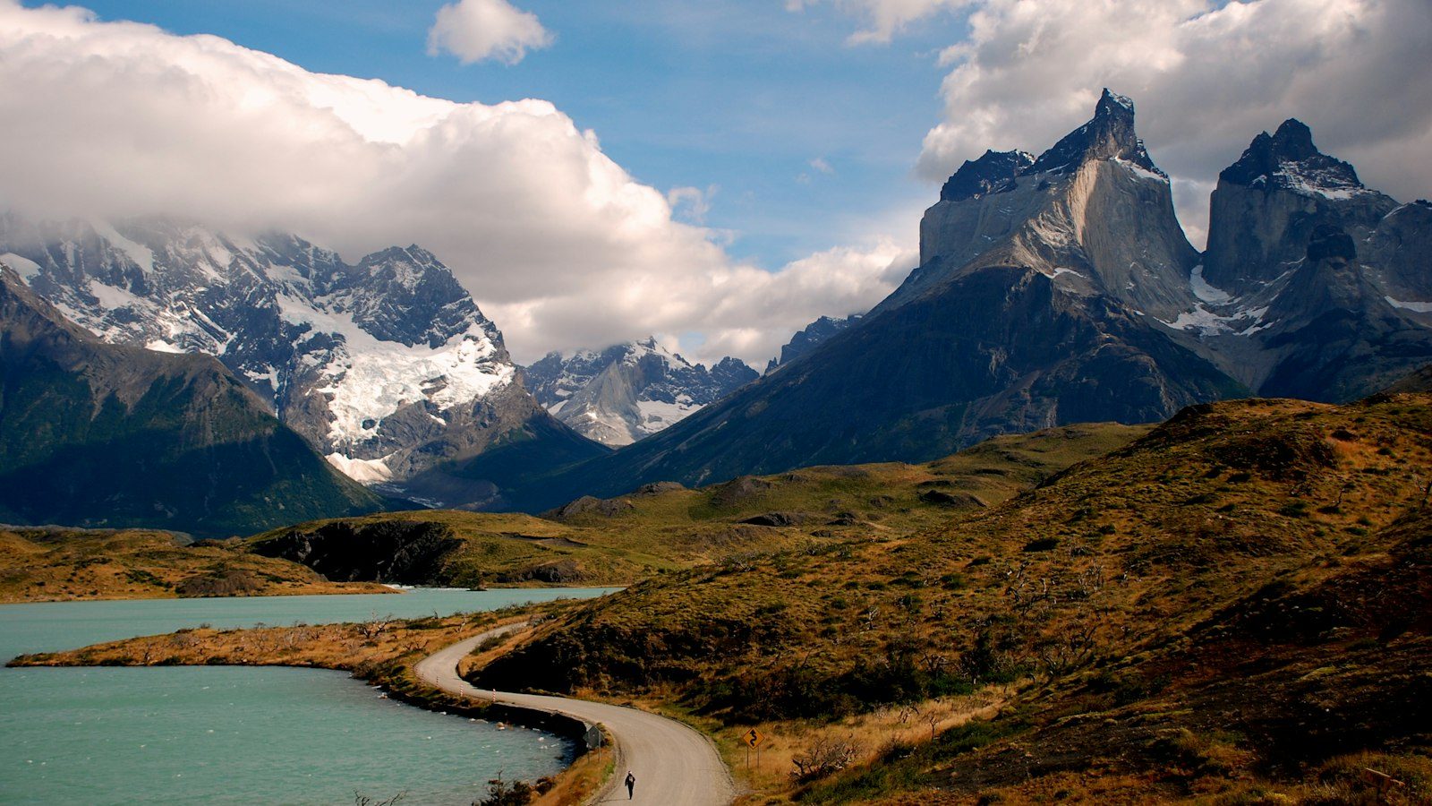 A winding road along turquoise Lake Pehoe leading toward the Cuernos del Paine in Torres del Paine, Patagonia